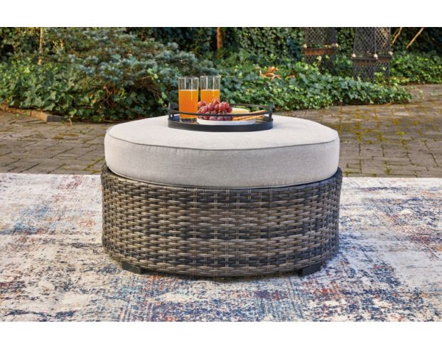 Round Woven Tray on Round Gray Ottoman as Coffee Table